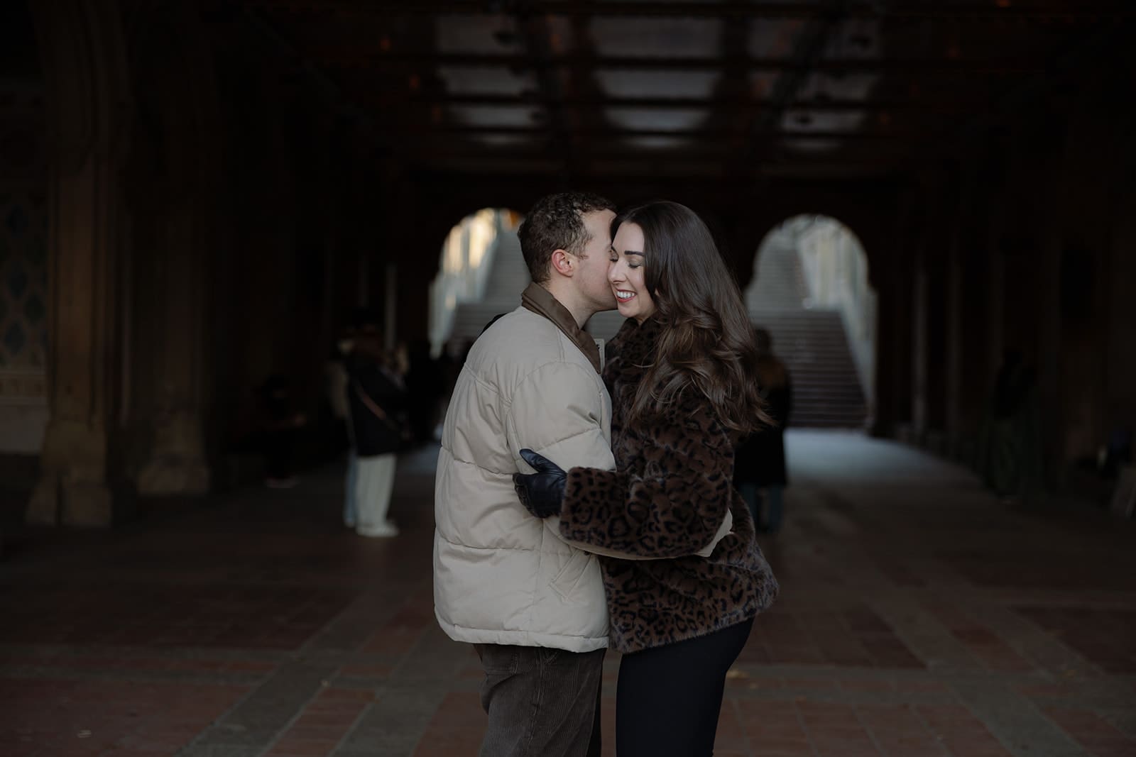 Carlie and Mat laughing during their winter couple session at Bethesda Terrace