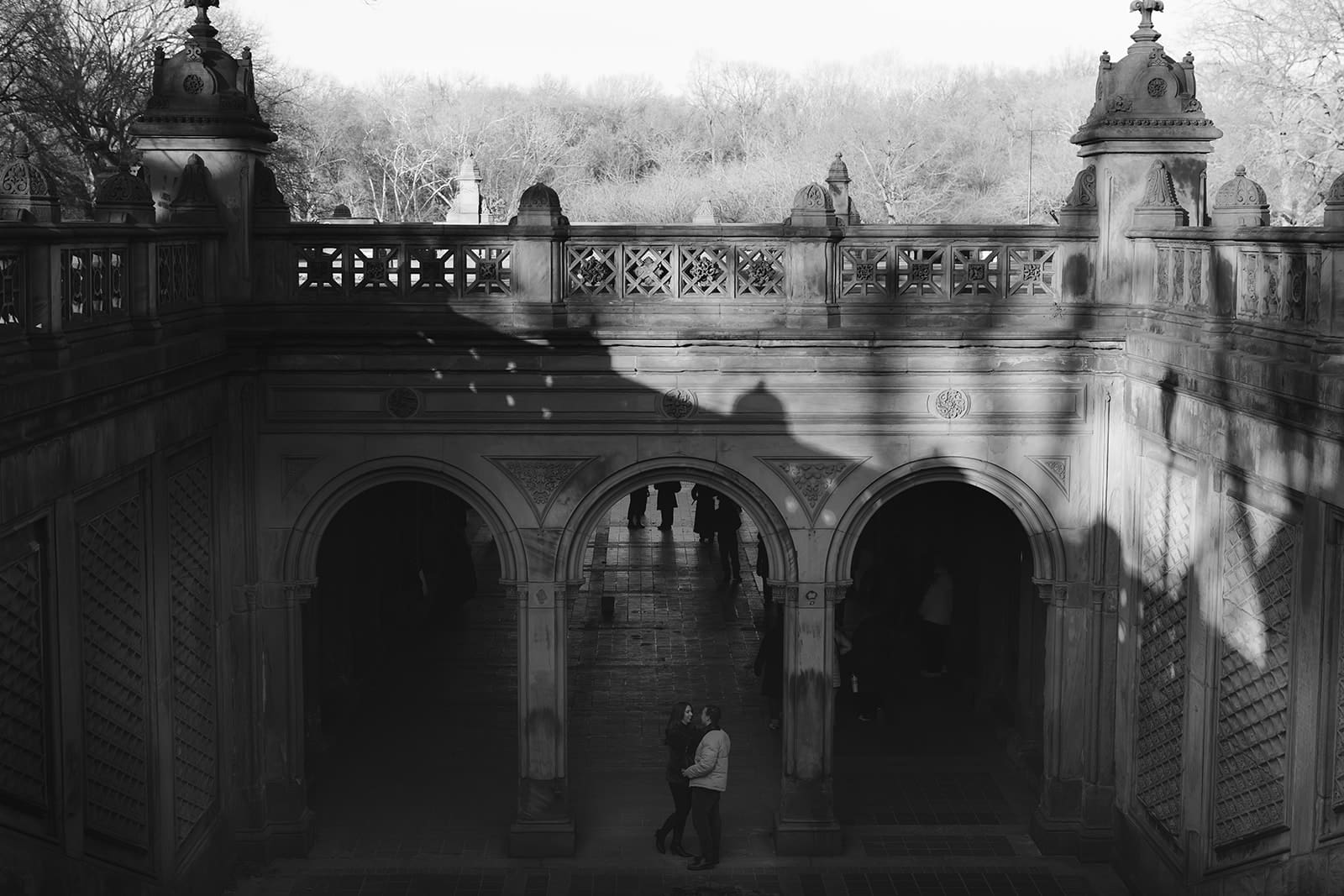 Carlie and Mat framed beneath Bethesda Terrace on a winter afternoon in Central Park