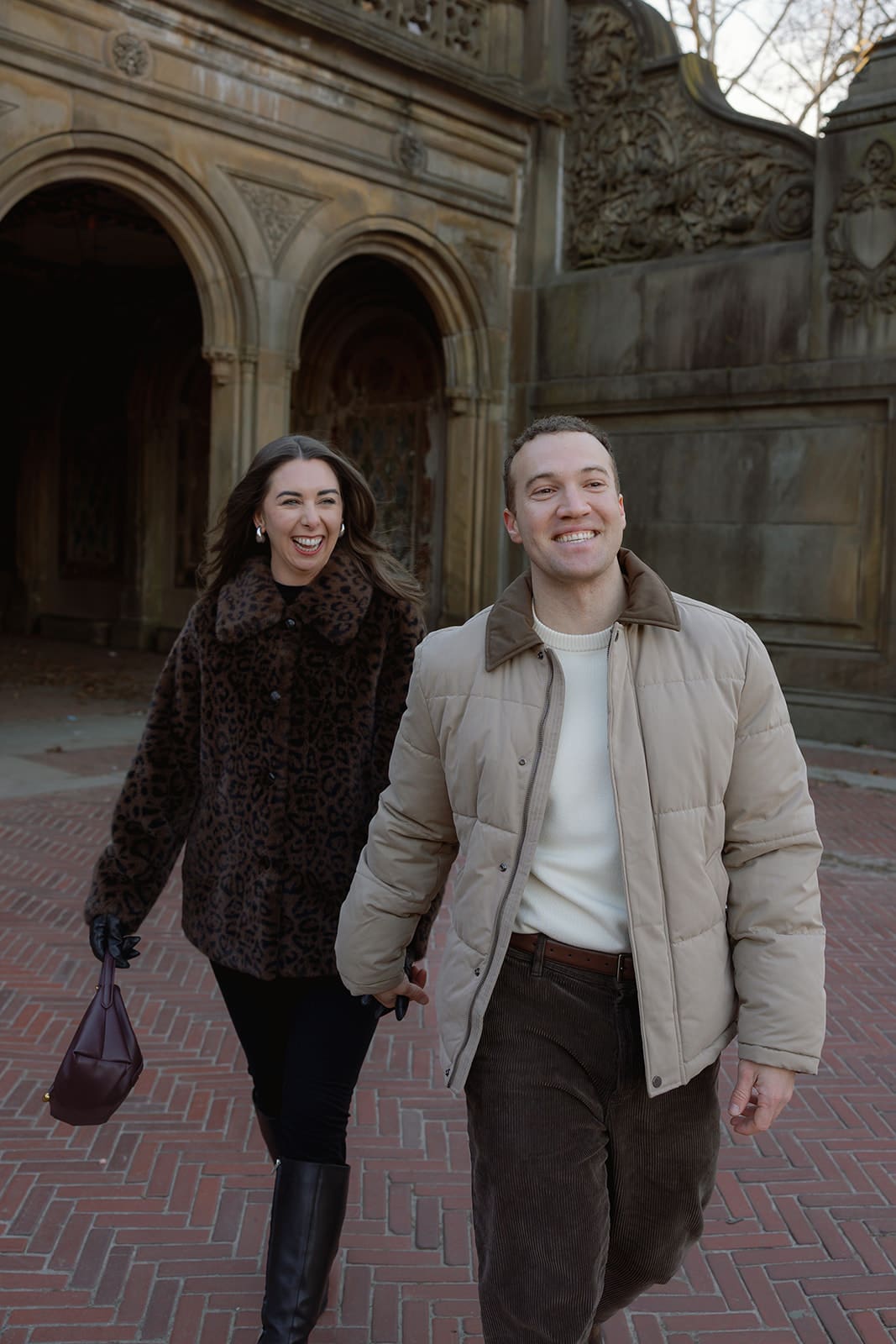 Carlie and Mat walking through Bethesda Terrace during a January photo session