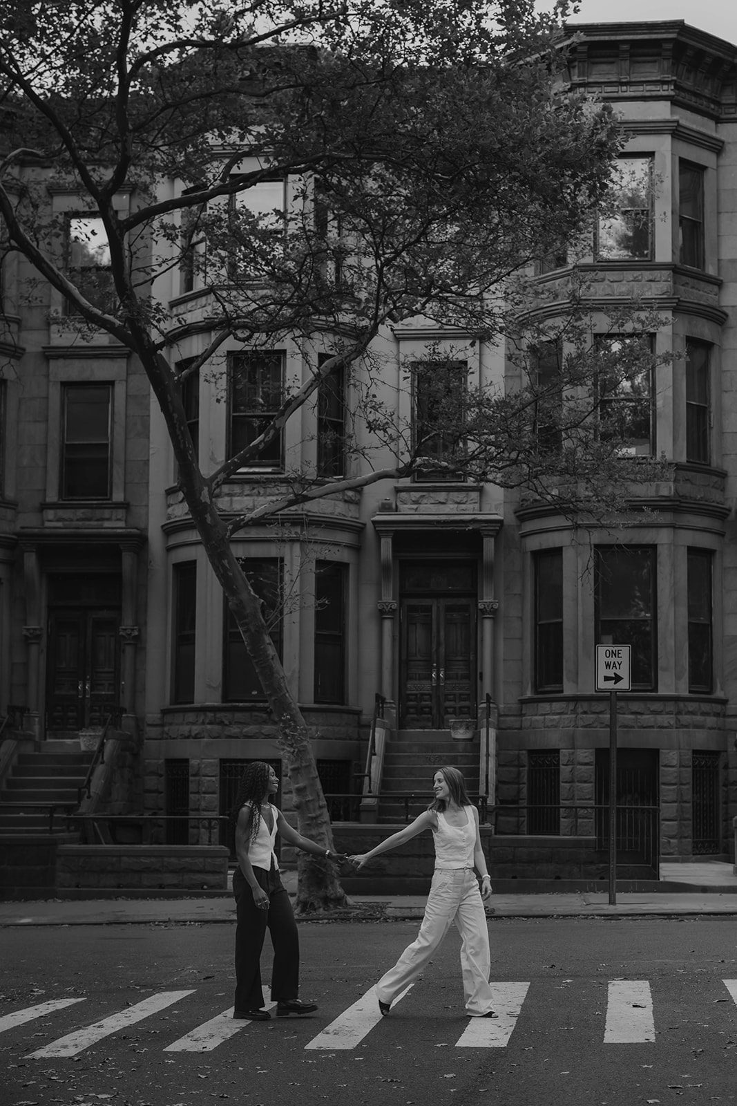 Black-and-white photograph of Cassia and Laura crossing a Park Slope street