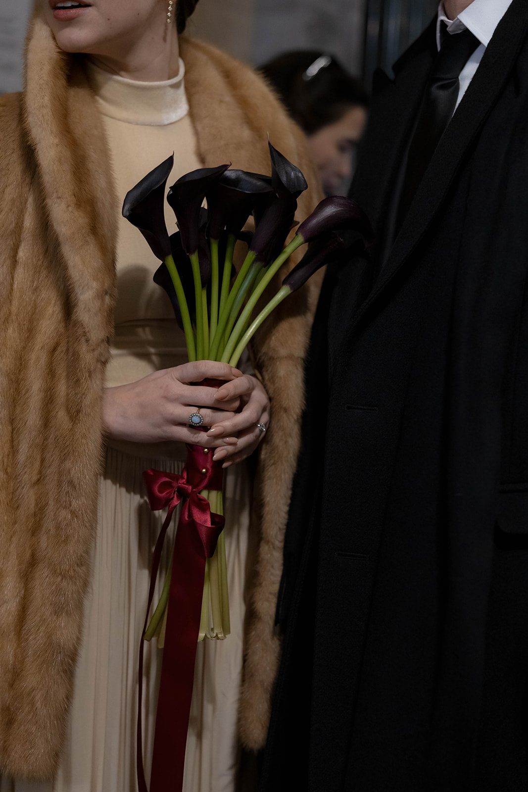 Claire holding a bouquet of dark calla lilies at the Manhattan Marriage Bureau