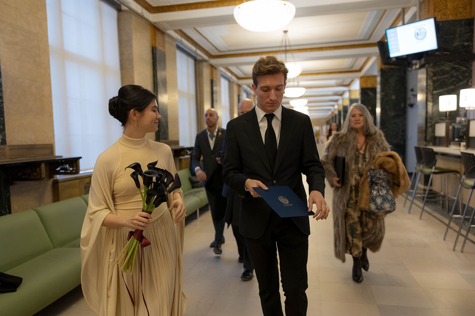 Claire and Andrey walking through the Marriage Bureau with their marriage certificate