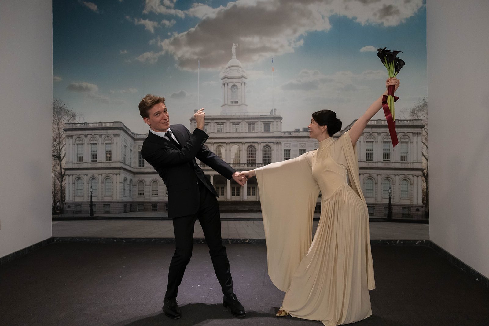 Claire and Andrey celebrating in front of the City Hall backdrop after their elopement