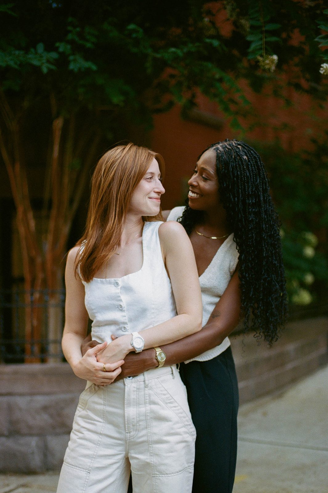 Cassia and Laura embracing on a Park Slope sidewalk photographed on 35mm film