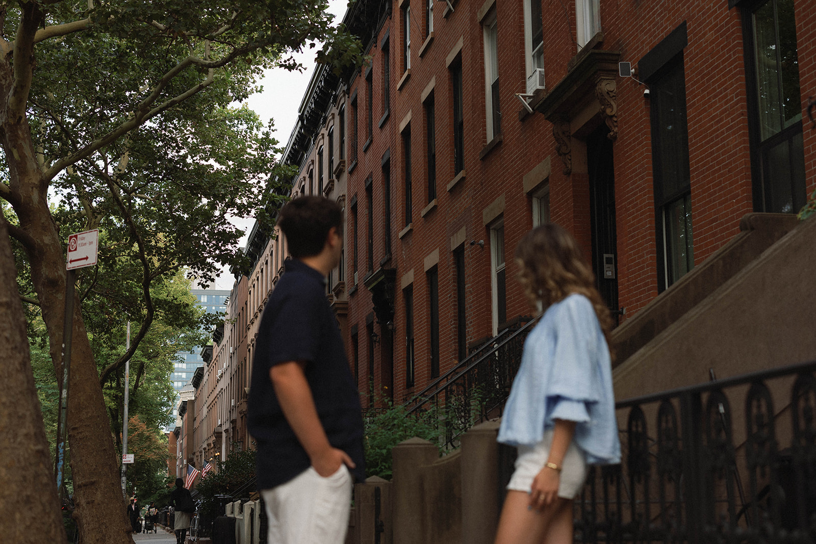 Sadie and David looking toward a row of Brooklyn brownstones