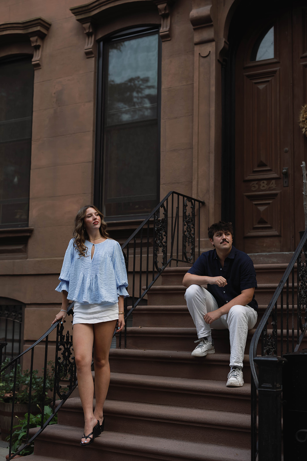 Sadie and David standing and sitting on a Brooklyn brownstone stoop