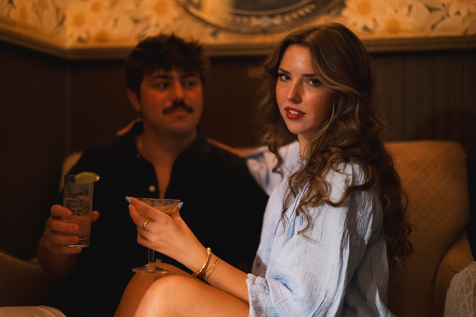 Sadie holding a cocktail with David seated beside her at Brooklyn Social