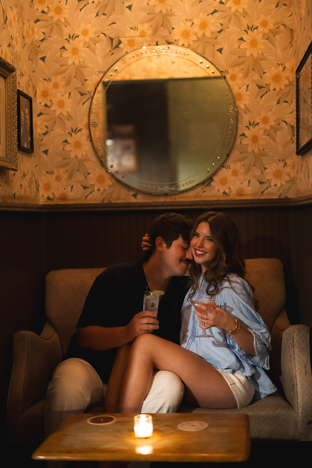 Sadie laughing as David leans close in a floral-wallpapered booth at Brooklyn Social