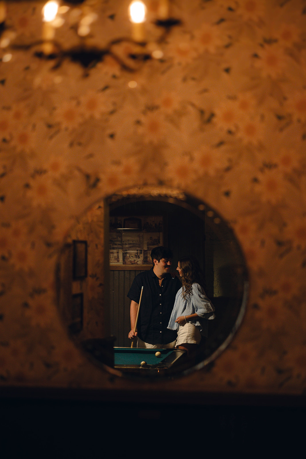 Sadie and David reflected in a round mirror beside the pool table at Brooklyn Social