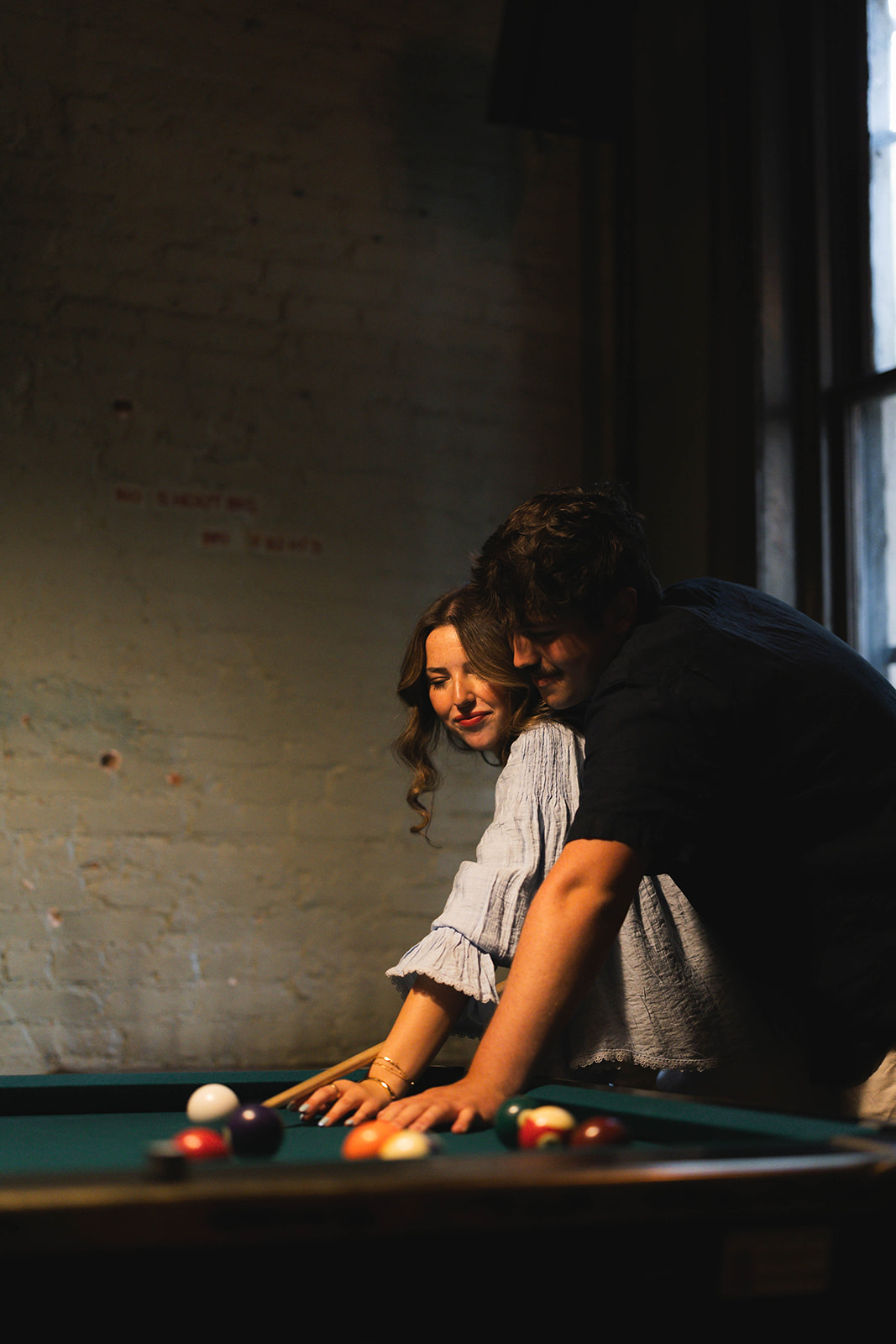 Sadie and David leaning together over the pool table at Brooklyn Social